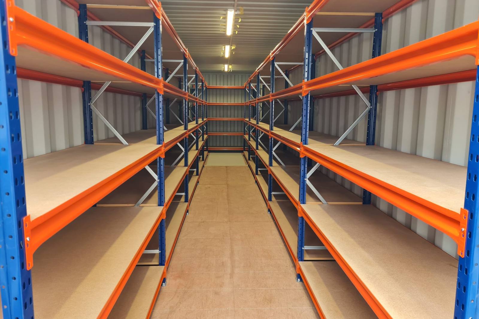 Shelving fitted down both walls inside a shipping container