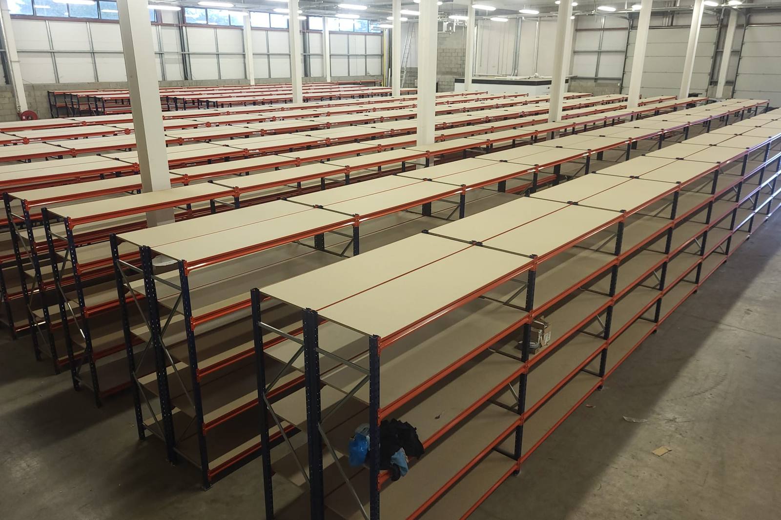 Long span shelving being installed across a warehouse floor
