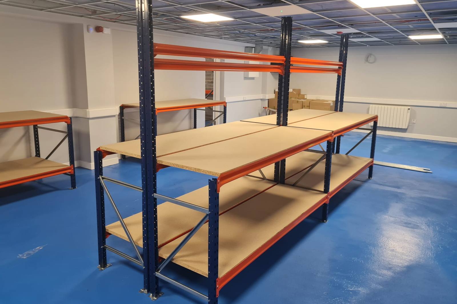 Two steel-framed workbenches with timber tops in a fitted-out room
